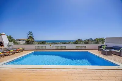 a swimming pool with blue water in a yard at Villa Marrachinho by Villa Plus in Albufeira