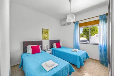 a bedroom with two beds and a window at Villa Marrachinho by Villa Plus in Albufeira