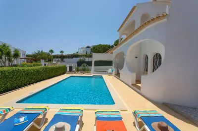 a villa with a swimming pool and lounge chairs at Villa Medeira by Villa Plus in Albufeira