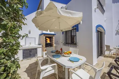 a kitchen with white cabinets and a stainless steel refrigerator at Villa Casa Michelle by Villa Plus in Almancil