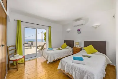 a bedroom with two beds and a view of the ocean at Villa Praia by Villa Plus in Galé