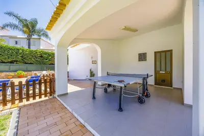 a ping pong table on the patio of a house at Villa Praia by Villa Plus in Galé