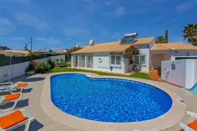 a swimming pool in front of a house at Villa Rocchi by Villa Plus in Albufeira