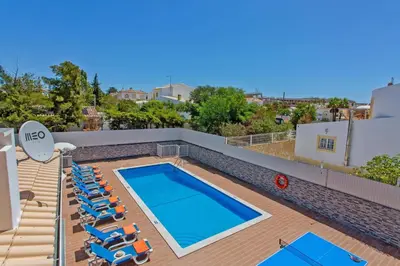 a white bedroom with a bed and a chair at Villa Sea Star by Villa Plus in Albufeira