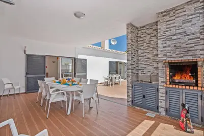 a dining room with a table and a fireplace at Villa Sea Star by Villa Plus in Albufeira