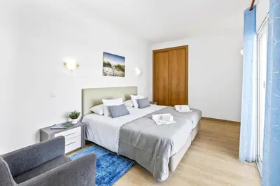 a bedroom with a bed and a couch and a window at Villa Sea Star by Villa Plus in Albufeira