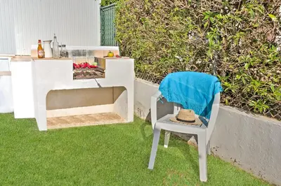 a hat sitting on a chair in the grass at Villa Vitor by Villa Plus in Albufeira