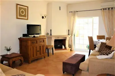 a living room with a tv on a wooden dresser at Moradia da Encosta- Vilamoura in Vilamoura