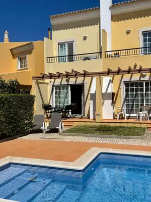 a villa with a swimming pool in front of a house at Moradia da Encosta- Vilamoura in Vilamoura