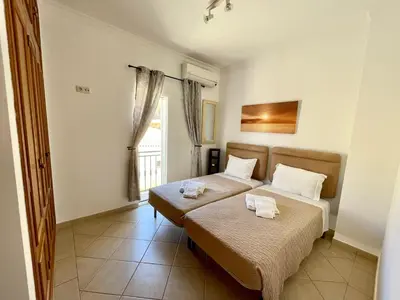 a bedroom with two beds and a window at Moradia da Encosta- Vilamoura in Vilamoura