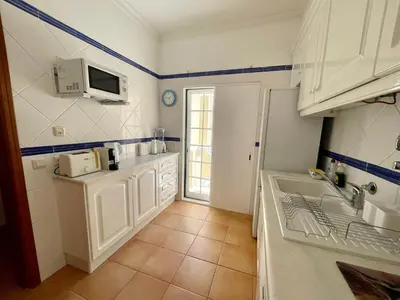 a kitchen with white cabinets and a sink at Moradia da Encosta- Vilamoura in Vilamoura