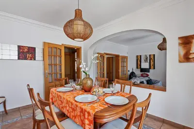 a dining room with a table with chairs and a table at Villa Bali by Villa Plus in Albufeira