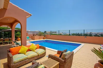 a patio with a couch and a swimming pool at Villa Bali by Villa Plus in Albufeira