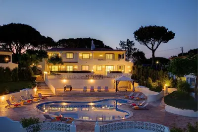 a large house with a swimming pool at night at Villa Beirais by Villa Plus in Vale do Lobo