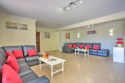 a living room with couches and red pillows at Villa Beirais by Villa Plus in Vale do Lobo
