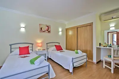 a bedroom with two beds and two tables at Villa Beirais by Villa Plus in Vale do Lobo