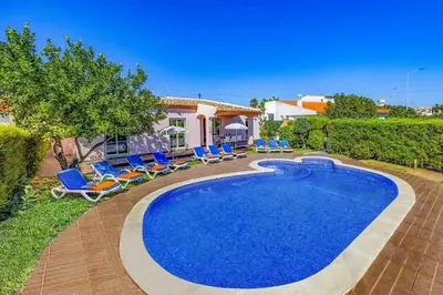 a swimming pool in a yard with chairs and a house at Villa Bolina by Villa Plus in Albufeira