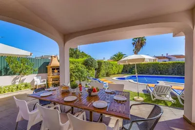 a patio with a table and chairs and a pool at Villa Bolina by Villa Plus in Albufeira