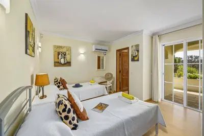 a hotel room with two beds and a balcony at Villa Canas by Villa Plus in Vale do Lobo