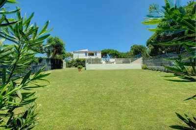 a backyard with a fence and a grass yard at Villa Canas by Villa Plus in Vale do Lobo
