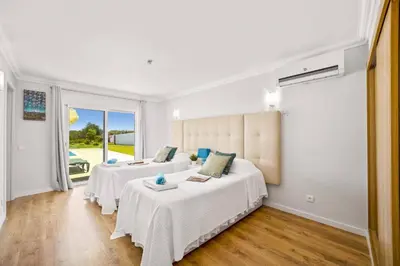 a bedroom with two beds and a large window at Villa Citrinos by Villa Plus in Almancil