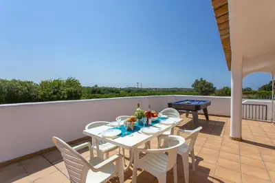 a patio with a table and chairs on a balcony at Villa Citrinos by Villa Plus in Almancil