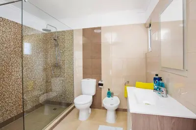 a bathroom with a toilet and a sink and a shower at Villa Citrinos by Villa Plus in Almancil