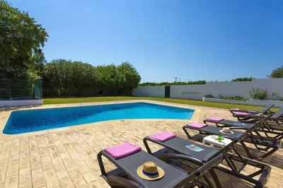 a group of chairs and a swimming pool at Villa Citrinos by Villa Plus in Almancil