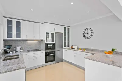 a white kitchen with white cabinets and appliances at Villa Pianda by Villa Plus in Almancil