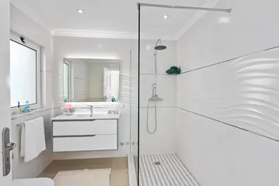 a white bathroom with a shower and a sink at Villa Pianda by Villa Plus in Almancil