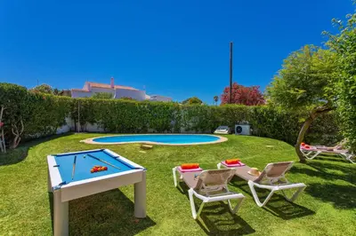 a backyard with a ping pong table and chairs and a trampoline at Villa Sueste by Villa Plus in Albufeira
