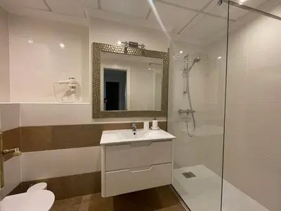 a bathroom with a sink and a shower with a mirror at Falesia Beach Apartment in Albufeira