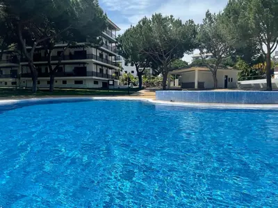 a large blue swimming pool in front of a building at Falesia Beach Apartment in Albufeira