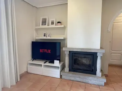 a living room with a fireplace and a tv at Falesia Beach Apartment in Albufeira