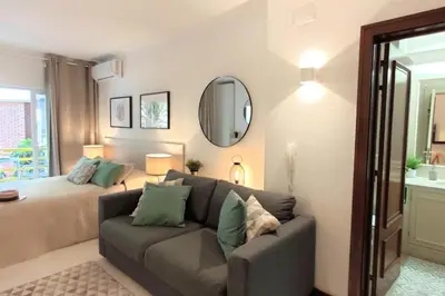 a living room with a couch and a bed at Al-Charb Studio in Quarteira