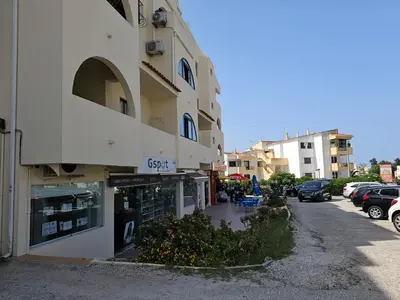 a building with a store on the side of a street at T1 Poente da Aldeia 336 Albufeira in Albufeira