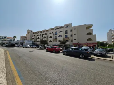 a street with cars parked in front of a building at T1 Poente da Aldeia 336 Albufeira in Albufeira