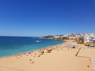 a group of people on a beach with the ocean at T1 Poente da Aldeia 336 Albufeira in Albufeira