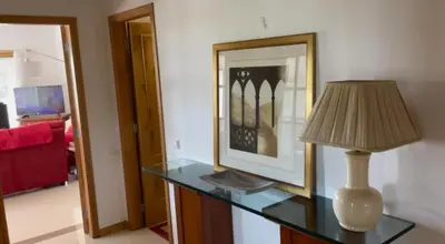 a lamp on a glass table in a living room at Praia da Falésia Alfa Mar Albufeira in Olhos de Água