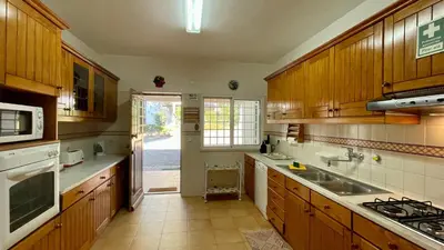 a large kitchen with wooden cabinets and a sink at Sol by Check-in Portugal in Vilamoura