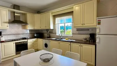 a kitchen with yellow cabinets and a white refrigerator at Ellegance by Check-in Portugal in Vilamoura