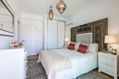 a white bedroom with a large white bed with red pillows at Riad Matias Galé - Luxury Villa with private pool, AC, free wifi, 5 min from the beach in Guia
