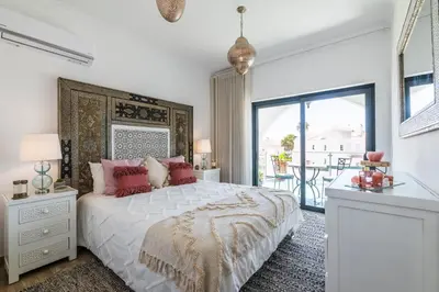 a white bedroom with a large bed and a balcony at Riad Matias Galé - Luxury Villa with private pool, AC, free wifi, 5 min from the beach in Guia
