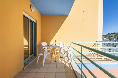 a balcony with a table and chairs at Marina Breeze Apartment with Pool - 900m from the Beach in Albufeira