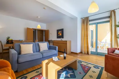 a living room with a blue couch and a table at Marina Breeze Apartment with Pool - 900m from the Beach in Albufeira