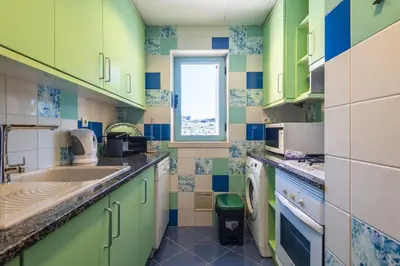 a small kitchen with green and blue tiles at Marina Breeze Apartment with Pool - 900m from the Beach in Albufeira