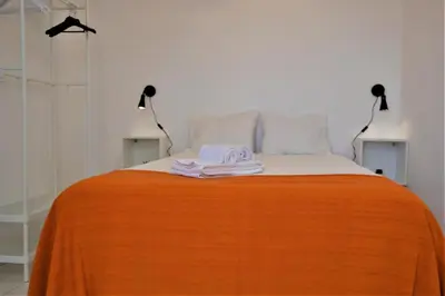 a white bedroom with a bed and white cabinets at Ria Beach Studio in Faro
