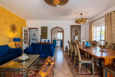 a living room with a table and a blue couch at Villa Oasis Galé - Luxury Villa with private pool, AC, free wifi, 5 min from the beach in Albufeira