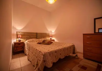 a bedroom with a bed and a dresser and lamp at ALGARVE TYPICAL DOWNTOWN HOUSE in Faro