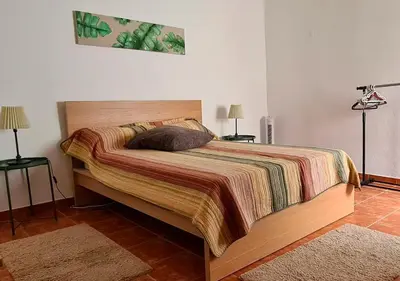a bed in a bedroom with two tables and two lamps at ALGARVE TYPICAL DOWNTOWN HOUSE in Faro
